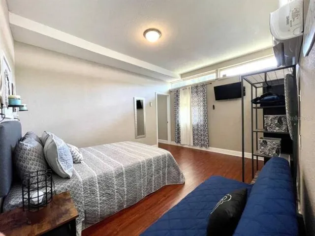 a bedroom with a bed and a painting on the wall