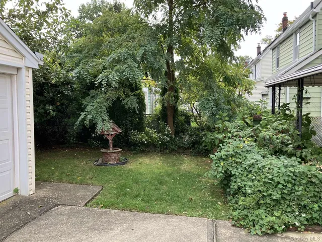 a view of a backyard with plants and a patio
