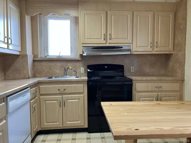 a kitchen with white cabinets and appliances
