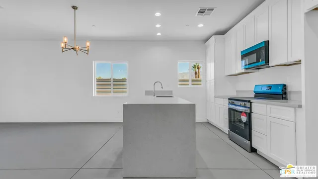 a kitchen with white cabinets and a stove top oven