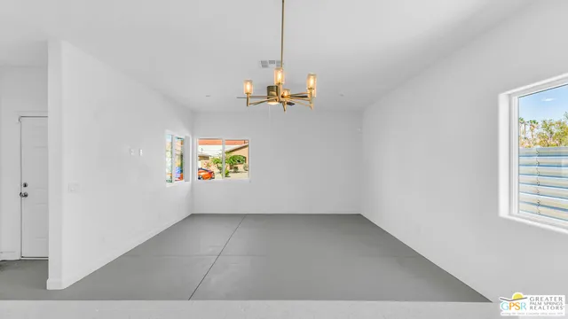 a kitchen with stainless steel appliances a sink a stove a refrigerator cabinets and a window