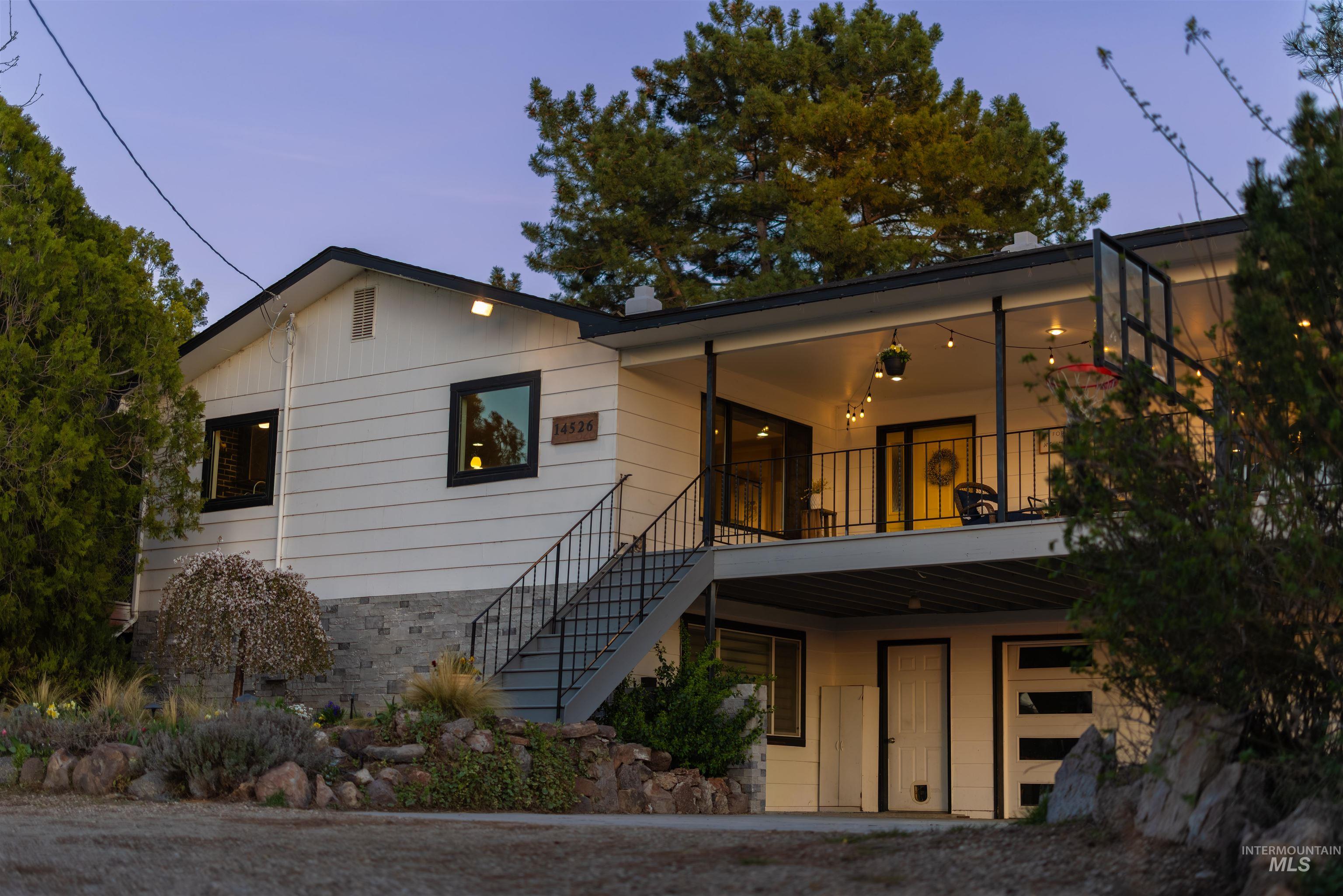 Split-level residence featuring white horizontal siding and a dark trim