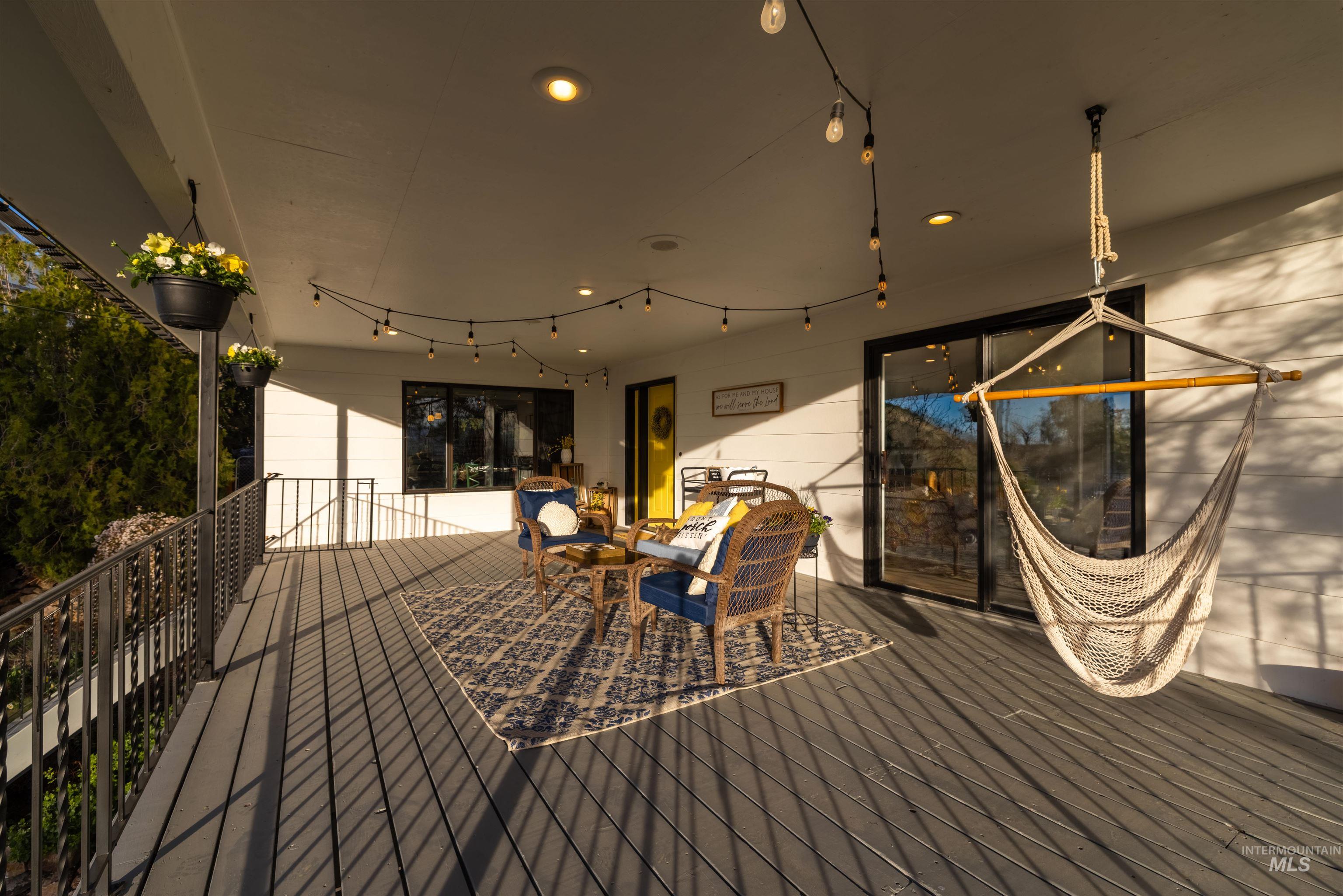 14526 Perfection Lane Caldwell, ID 83607 - Photo 18 of 24 Expansive covered deck featuring composite wood-finish flooring, metal railings, recessed ceiling lighting, and a sliding glass door