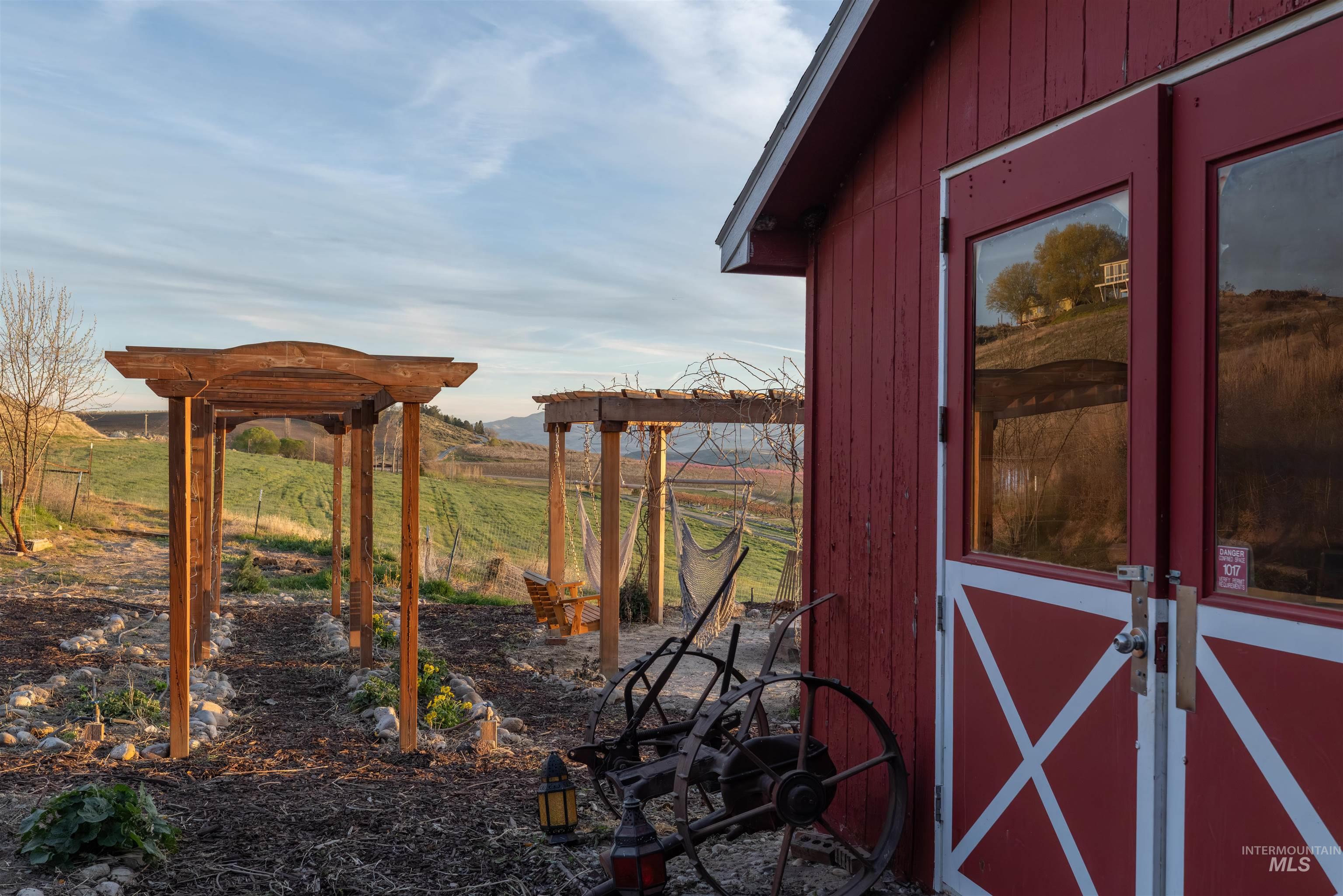 14526 Perfection Lane Caldwell, ID 83607 - Photo 19 of 24 Red-painted outbuilding with double doors featuring glass panels and a white cross-brace design