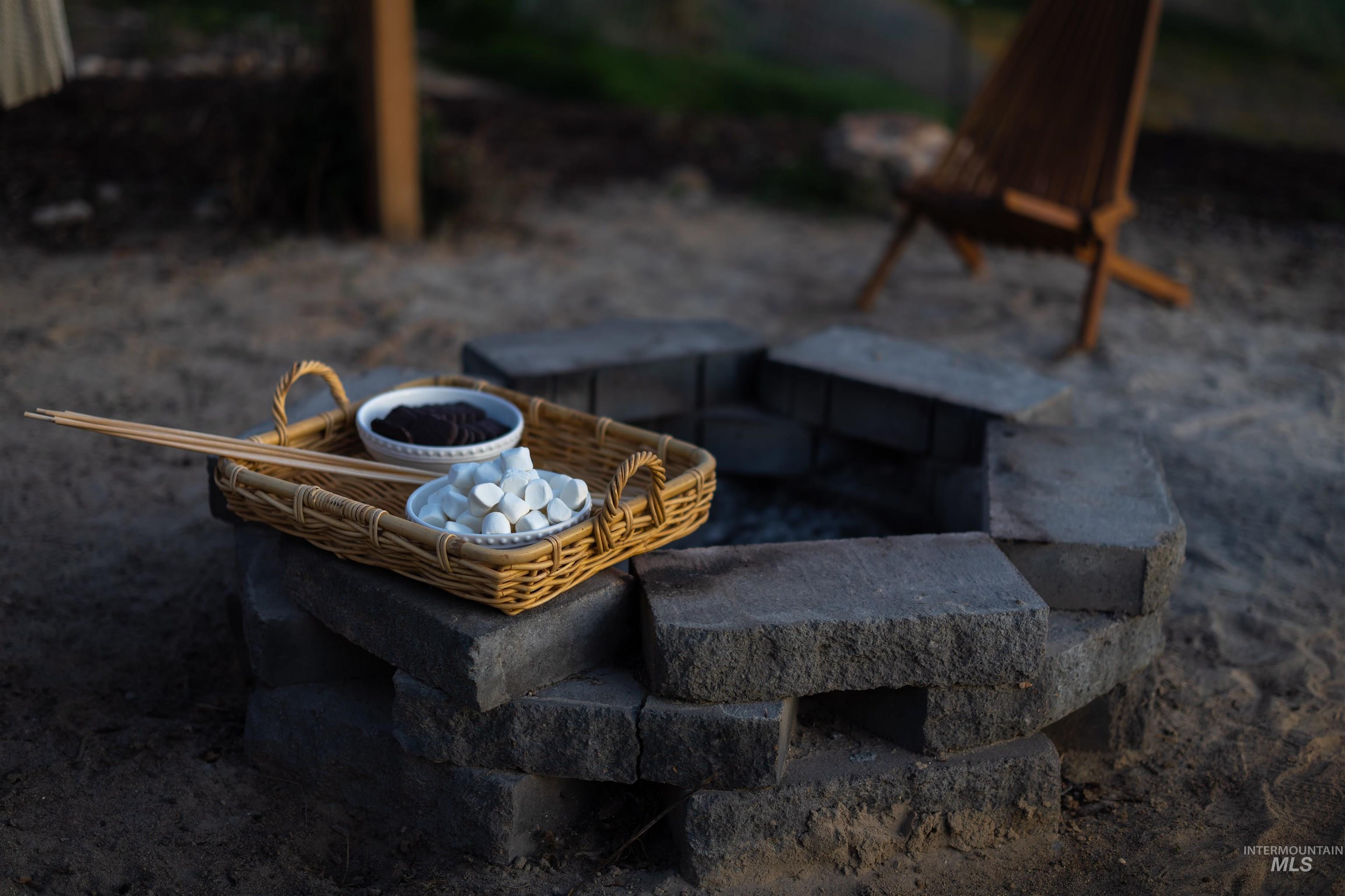 14526 Perfection Lane Caldwell, ID 83607 - Photo 22 of 24 Outdoor fire pit constructed with stone blocks, set within a gravel area