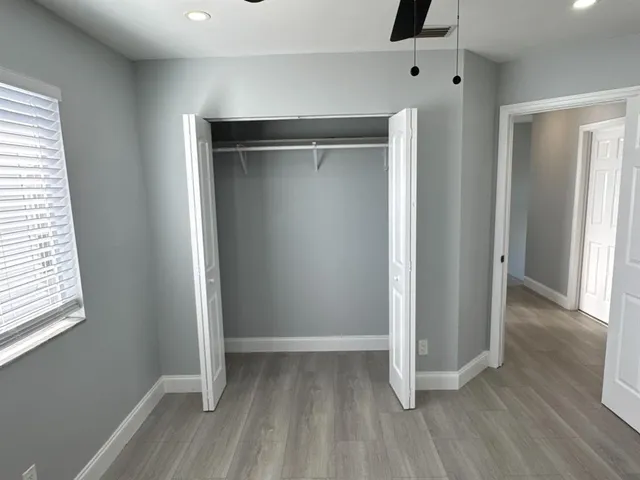 a view of an empty room with wooden floor and entryway