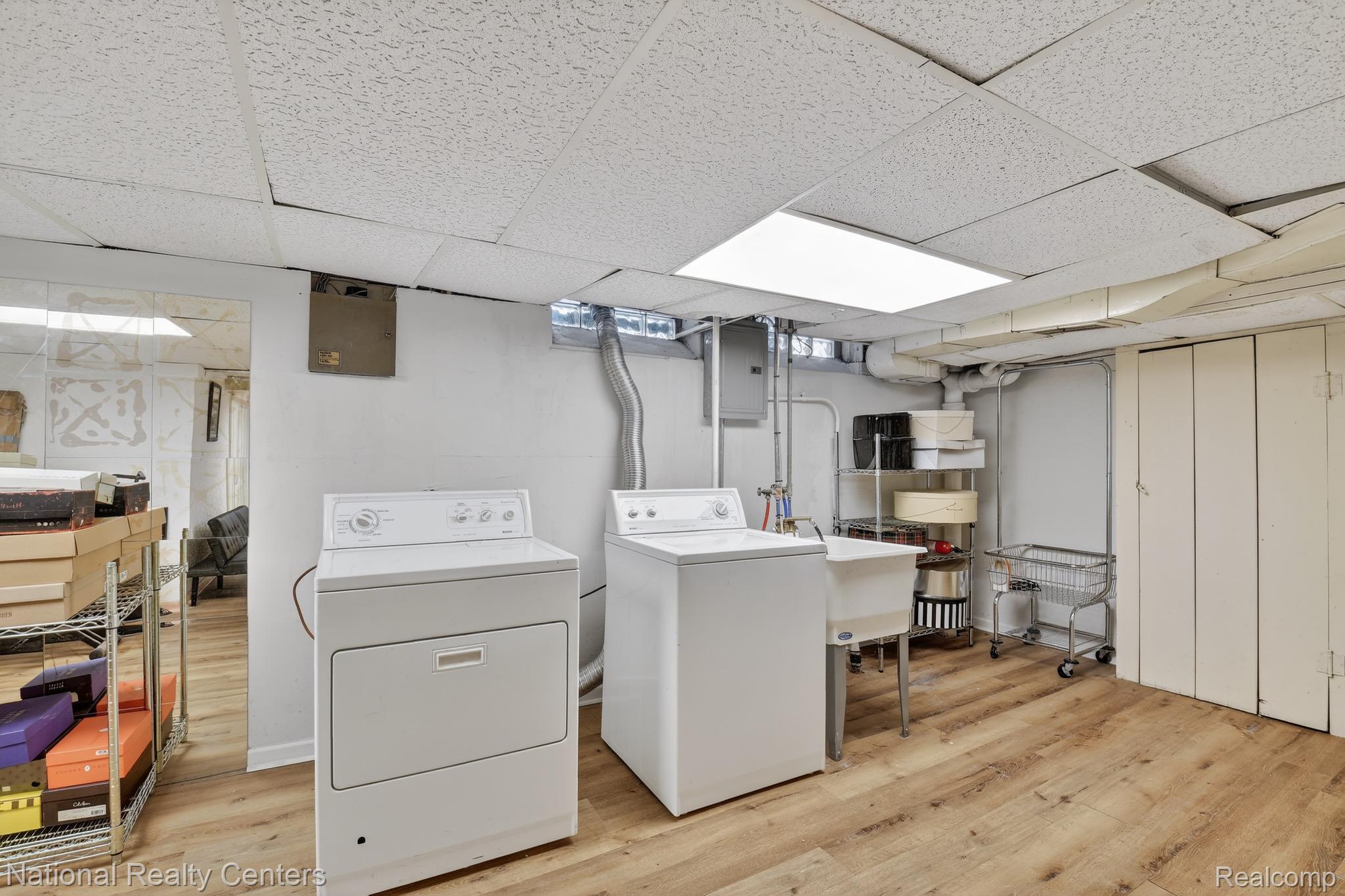 3956 Harvard Road Detroit, MI 48224 - Photo 33 of 44 Laundry area featuring light wood-style floors, a paneled ceiling, electric panel, and washer and clothes dryer