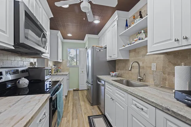 a kitchen with stainless steel appliances granite countertop a sink stove and refrigerator