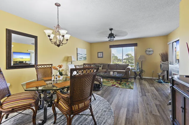 a view of a dining room with furniture a chandelier and wooden floor