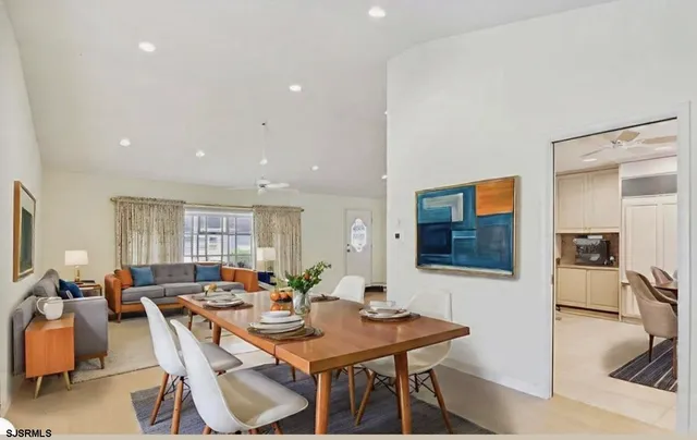 a living room with furniture a flat screen tv and a view of kitchen