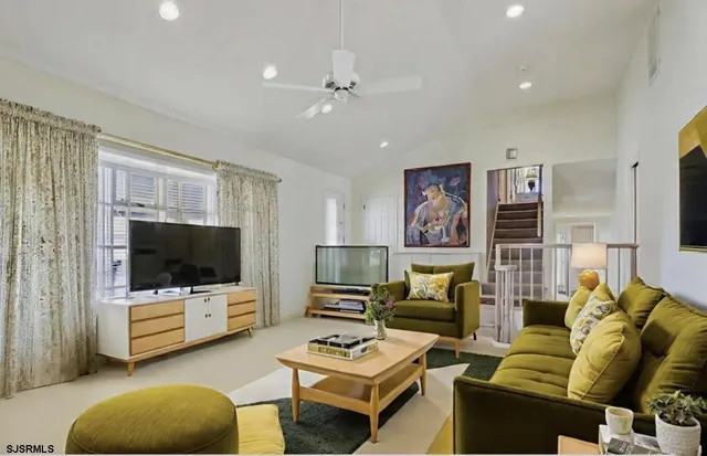 a living room with furniture a flat screen tv and a large window