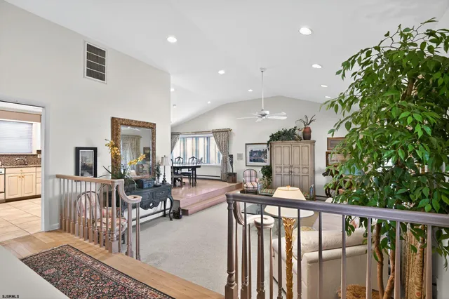 a kitchen with stainless steel appliances a refrigerator a stove a dining table and chairs with wooden floor