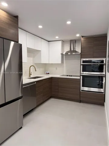 a kitchen with stainless steel appliances granite countertop a refrigerator and a sink