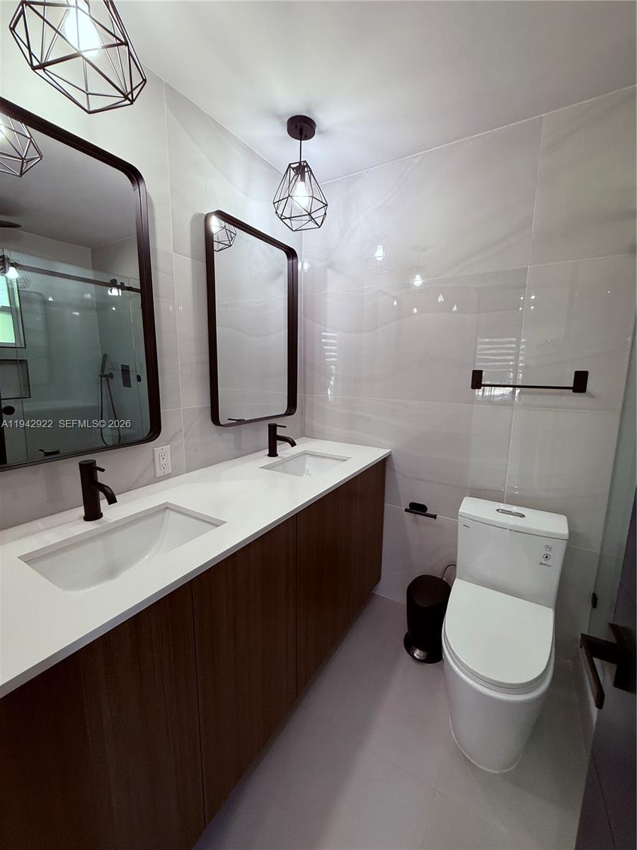 4430 Northwest 1st Avenue Miami, FL 33127 - Photo 26 of 31 a bathroom with a toilet sink double vanity and mirror