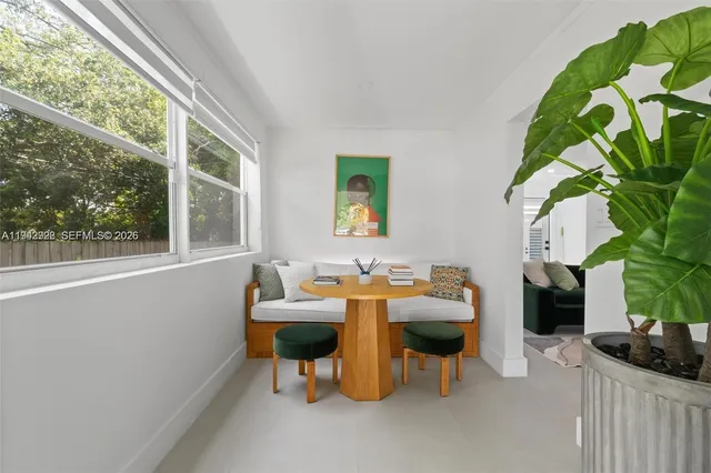 a living room with patio furniture and a potted plant