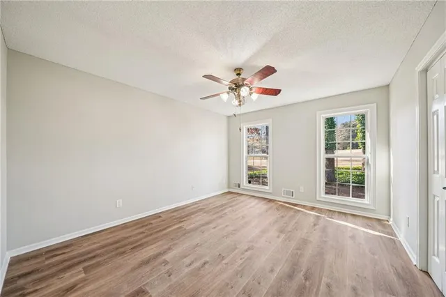a view of an empty room with a window and a ceiling fan
