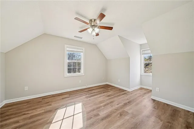 a view of a big room with wooden floor and windows in a room