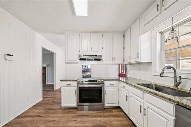 a kitchen with granite countertop white cabinets and white appliances
