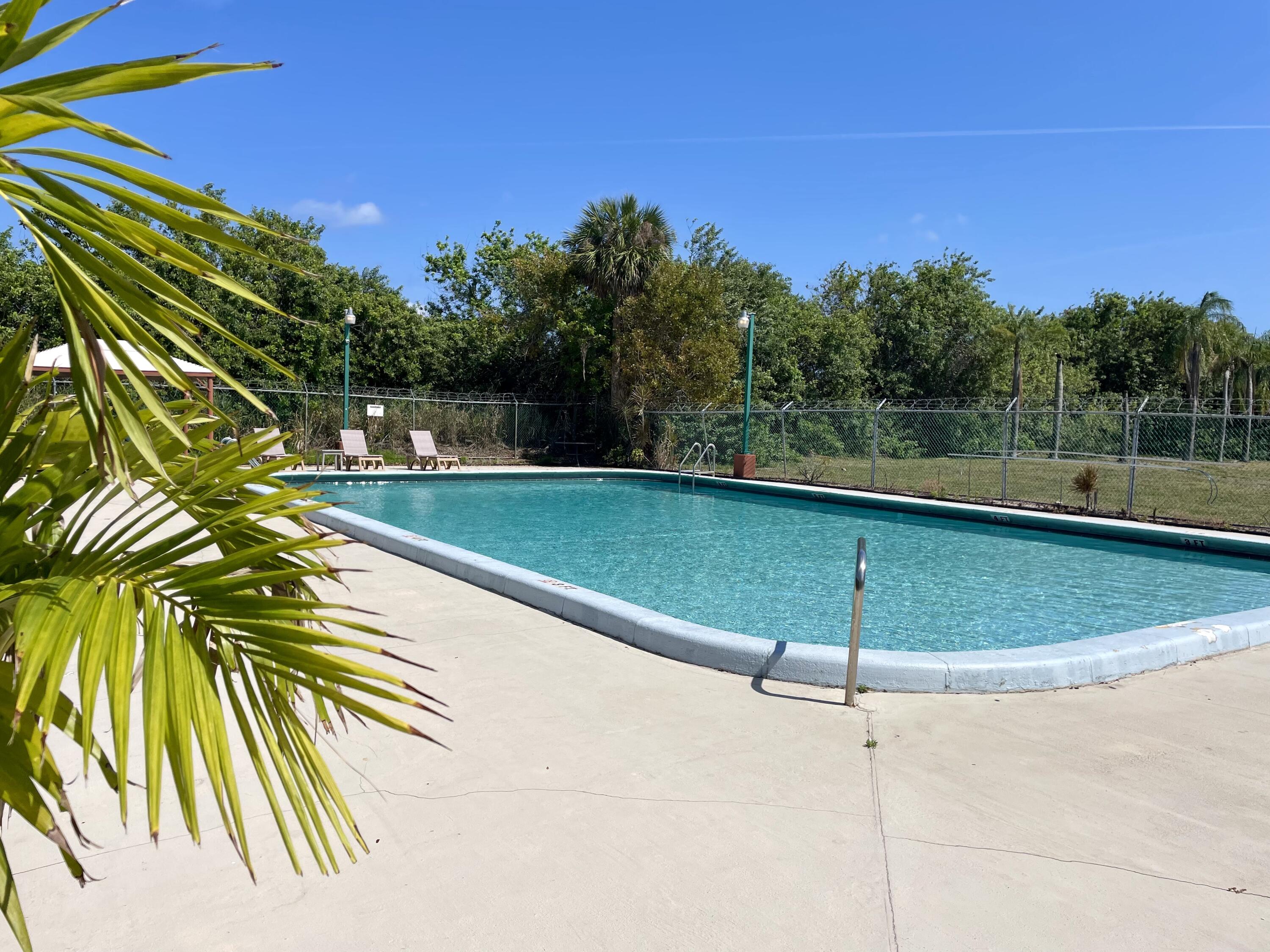 28 Crossings Circle, Unit B Boynton Beach, FL 33435 - Photo 14 of 19 a view of a swimming pool with a yard