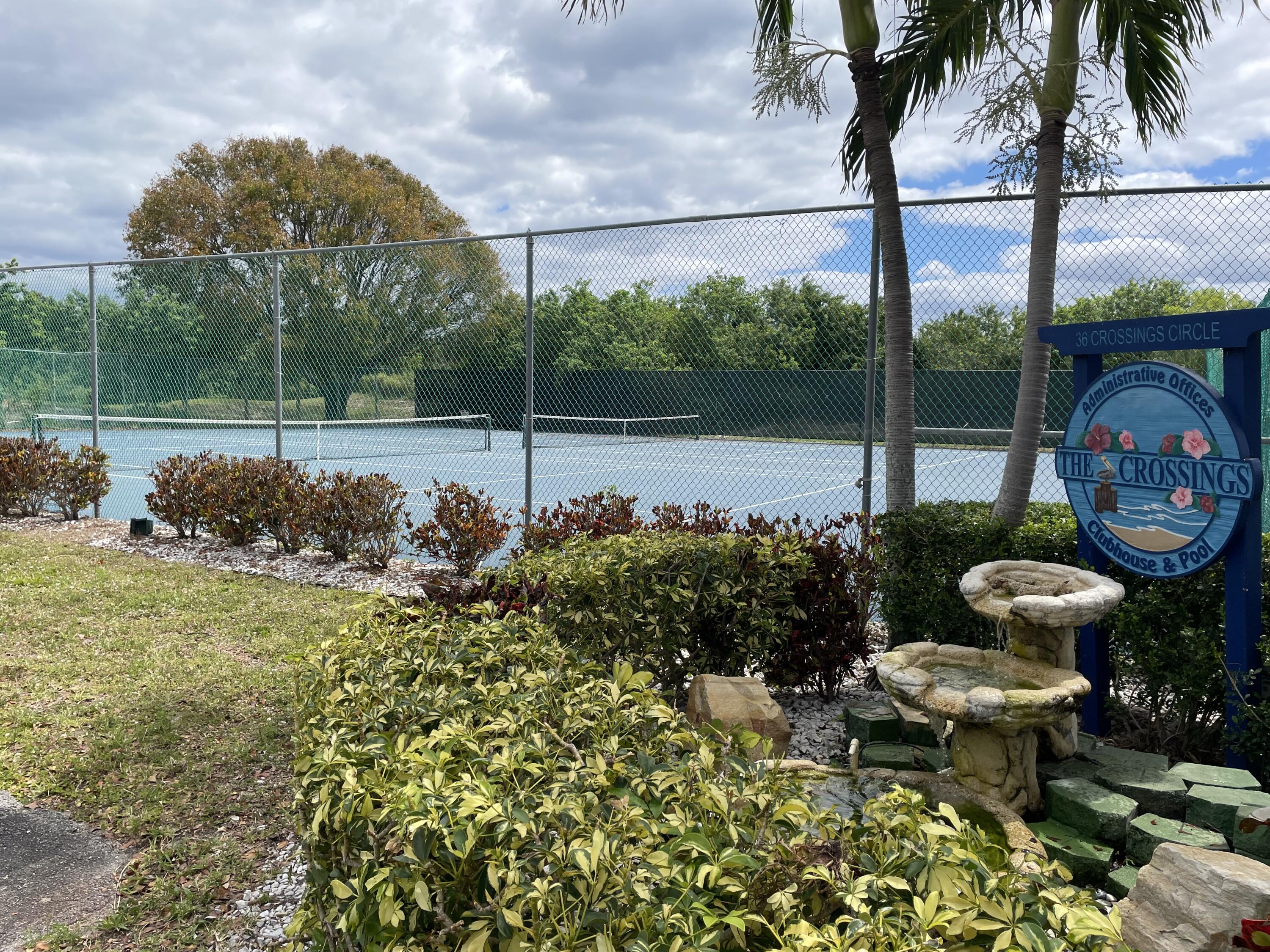 28 Crossings Circle, Unit B Boynton Beach, FL 33435 - Photo 18 of 19 a view of a swimming pool with a patio and a garden