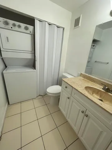 a bathroom with a granite countertop sink a mirror and a bathtub