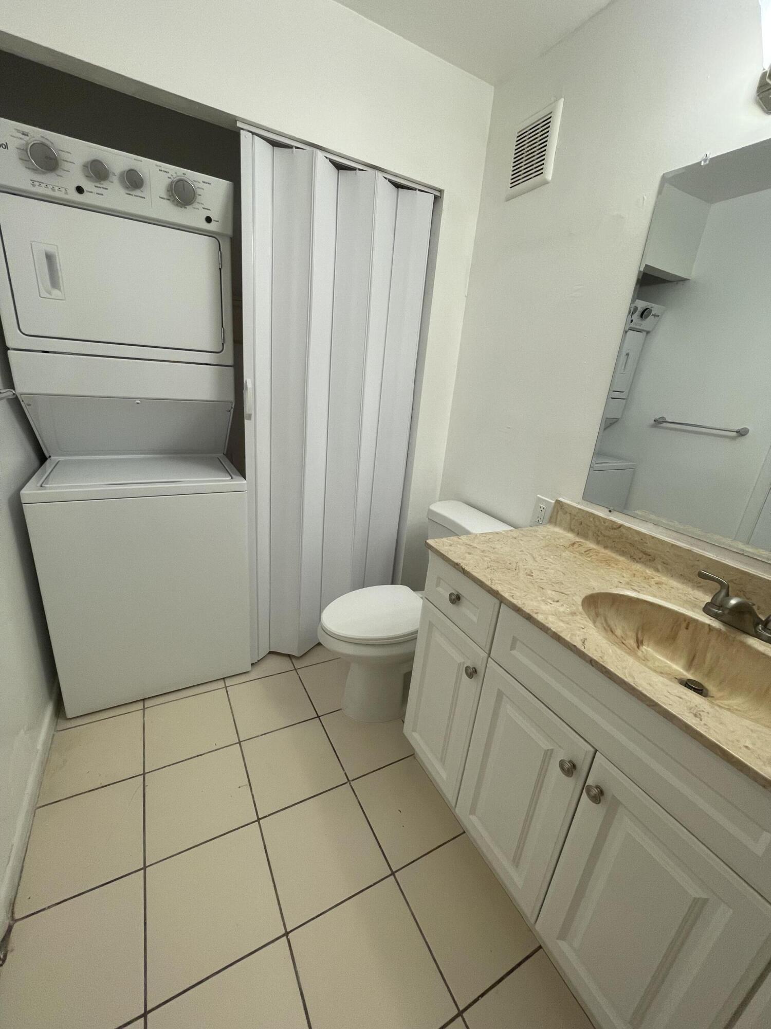 28 Crossings Circle, Unit B Boynton Beach, FL 33435 - Photo 7 of 19 a bathroom with a granite countertop sink a toilet a mirror and shower