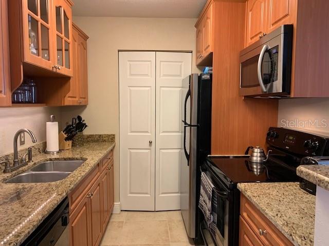 455 Alt 19, Unit 65 Palm Harbor, FL 34683 - Photo 4 of 11 a kitchen with stainless steel appliances granite countertop a sink stove and refrigerator