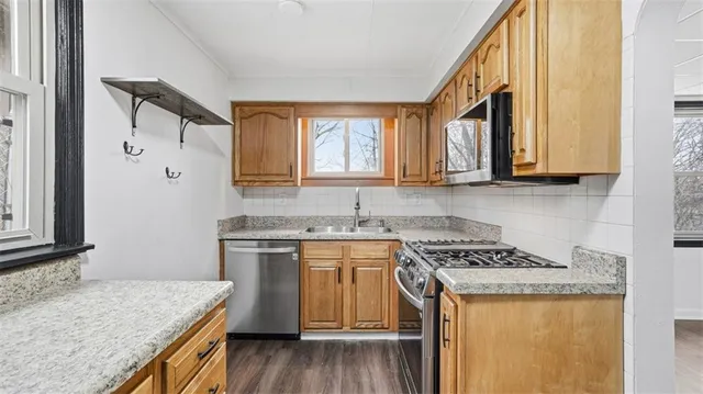 a kitchen with granite countertop a sink a stove and cabinets