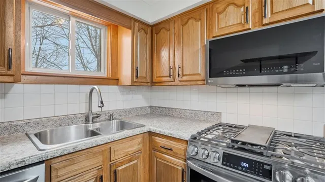 a kitchen with stainless steel appliances granite countertop a sink stove and cabinets