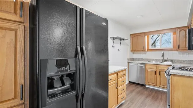 a kitchen with stainless steel appliances granite countertop a refrigerator and a sink