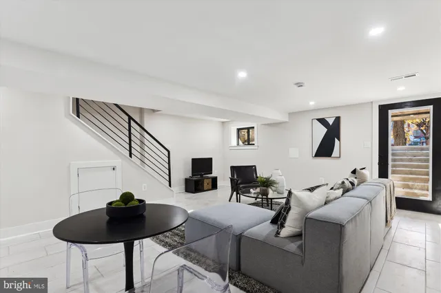 a living room with furniture and a view of kitchen