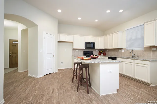 a kitchen with a sink cabinets and wooden floor