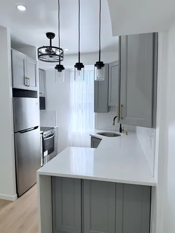 a kitchen with stainless steel appliances a sink a counter top space cabinets and stainless steel appliances