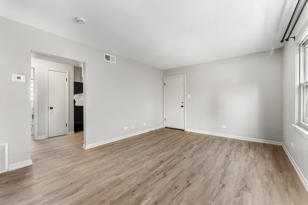 a view of an empty room with wooden floor