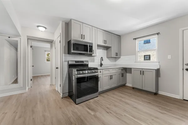 a kitchen with stainless steel appliances a white stove top oven a sink and a refrigerator