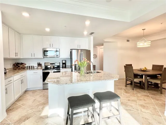 a kitchen with granite countertop a sink a counter top space appliances and cabinets