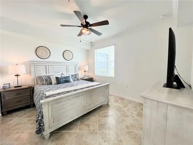 a bedroom with a bed and flat tv screen on the dresser