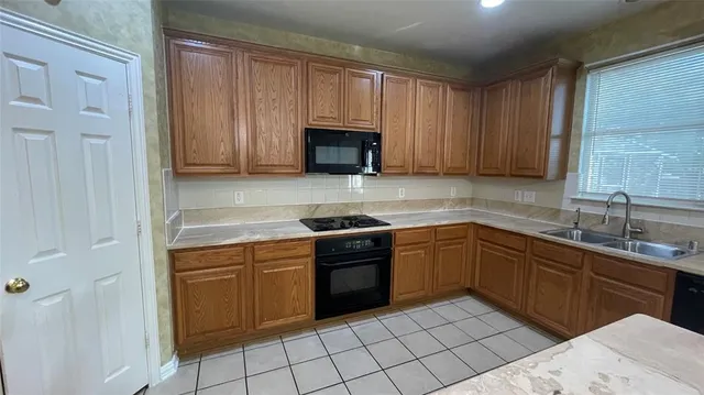 a kitchen with granite countertop a sink and a stove