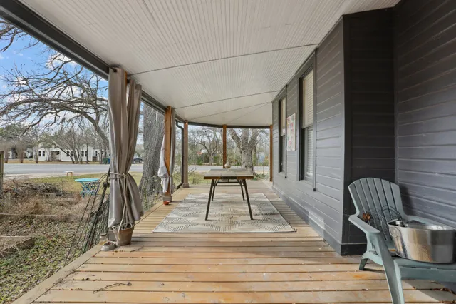 a view of a porch with wooden floor and outdoor seating