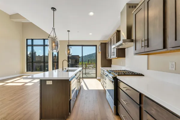a kitchen with stainless steel appliances granite countertop a sink a stove and a refrigerator