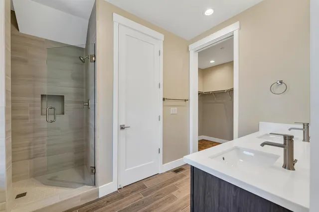 a bathroom with a double vanity sink a mirror and a bathtub