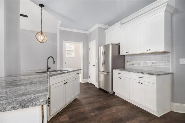 a kitchen with white cabinets and stainless steel appliances