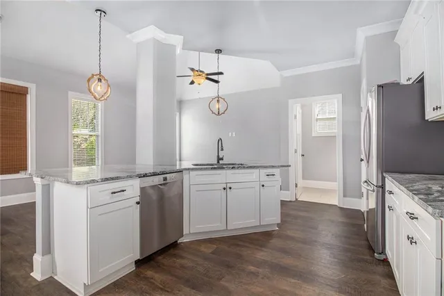 a bathroom with a granite countertop sink a toilet a mirror and shower