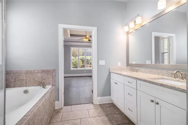 a bathroom with a tub sink and mirror