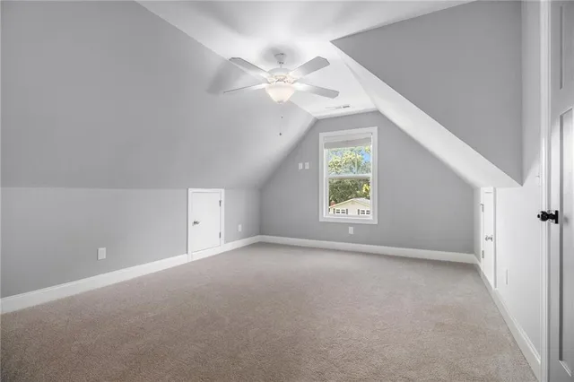 an empty room with a window and a ceiling fan