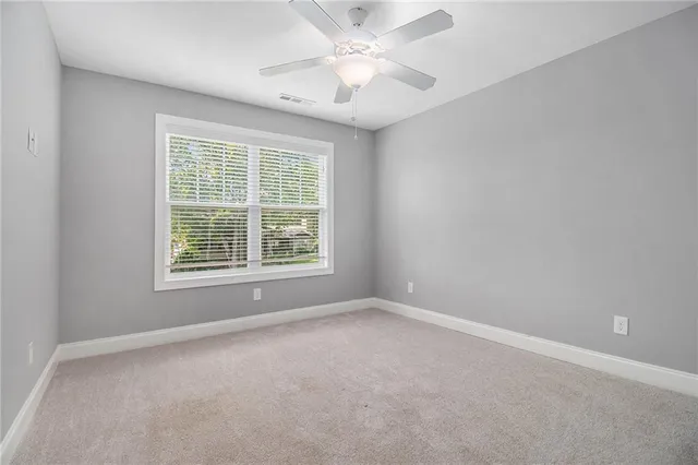 an empty room with a window and a ceiling fan