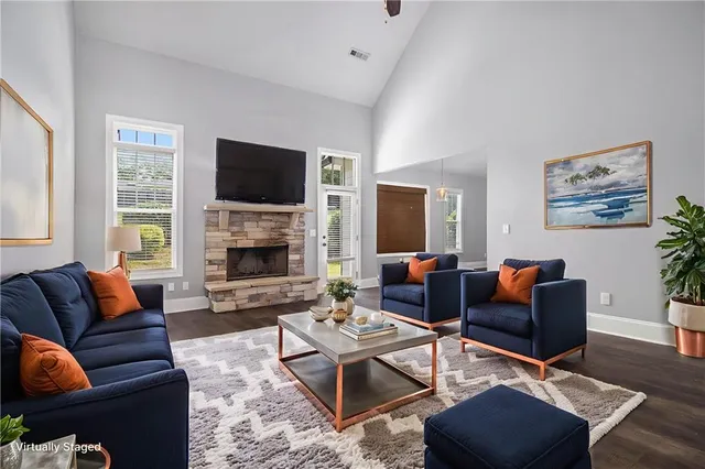 a living room with furniture a flat screen tv and a fireplace