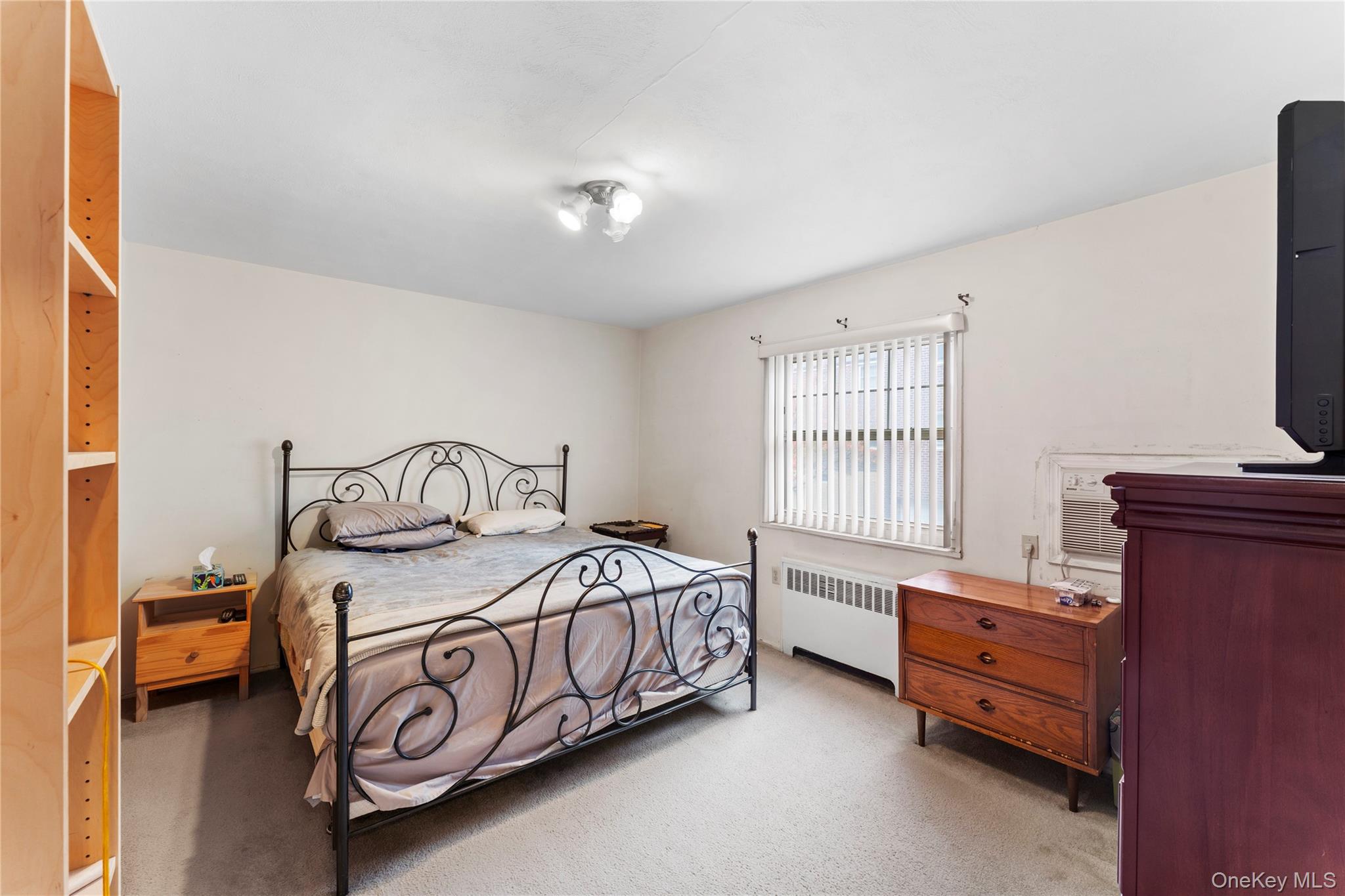 251-29 61st Avenue, Unit 2719 Queens, NY 11362 - Photo 12 of 19 a bedroom with a bed and a tv