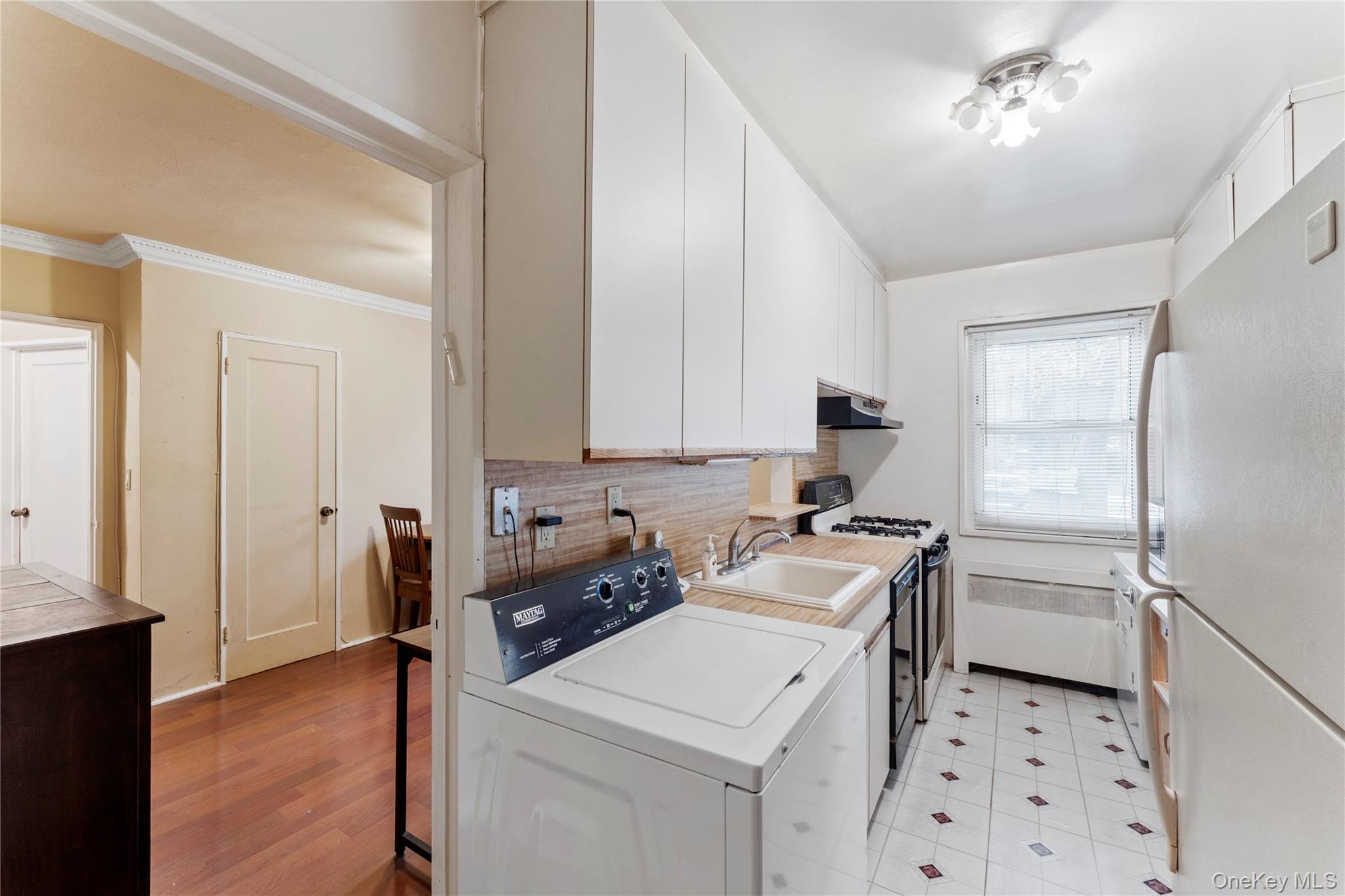 251-29 61st Avenue, Unit 2719 Queens, NY 11362 - Photo 4 of 19 a kitchen with a sink stove and refrigerator