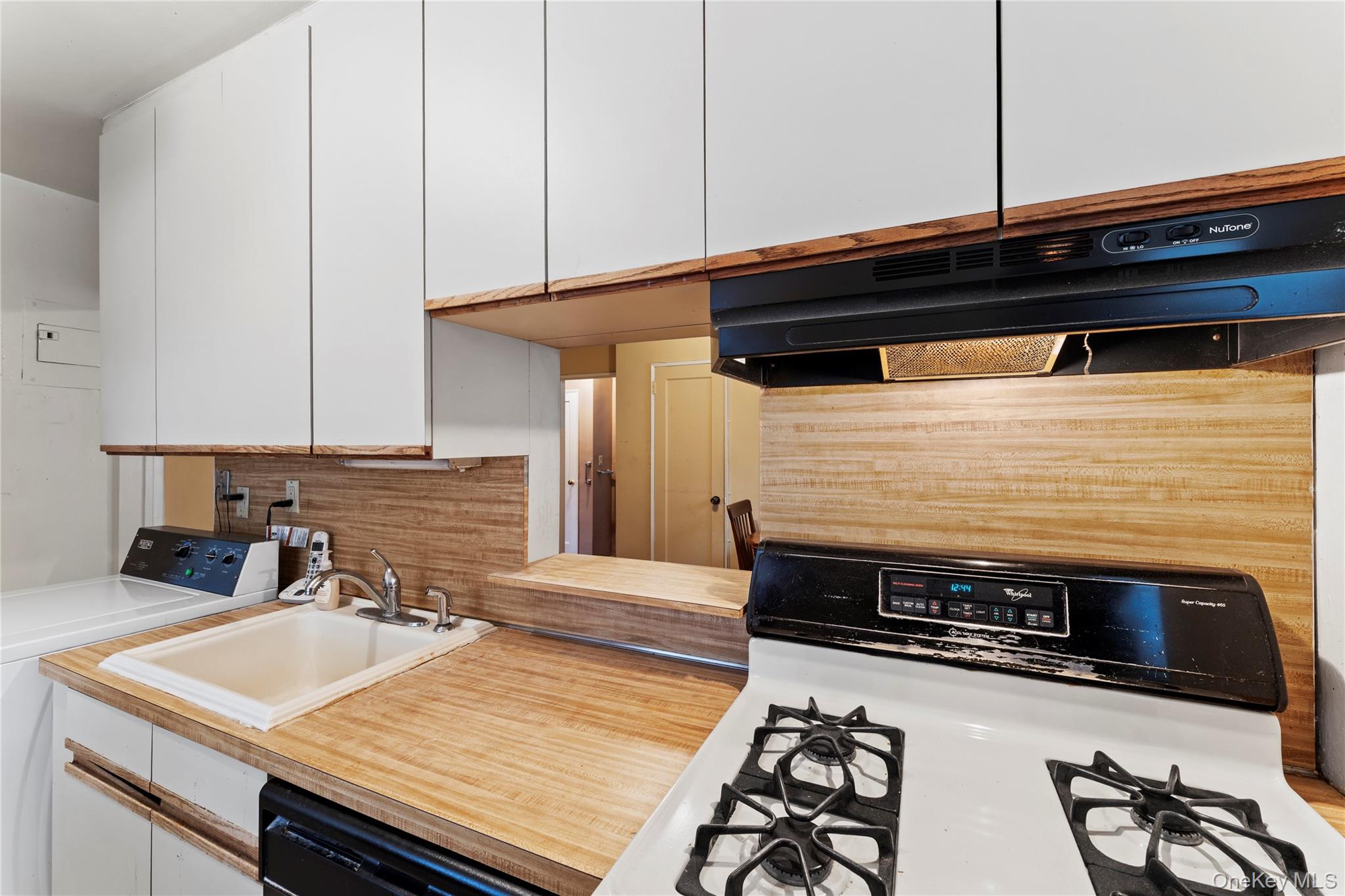 251-29 61st Avenue, Unit 2719 Queens, NY 11362 - Photo 7 of 19 a kitchen with a stove and a microwave